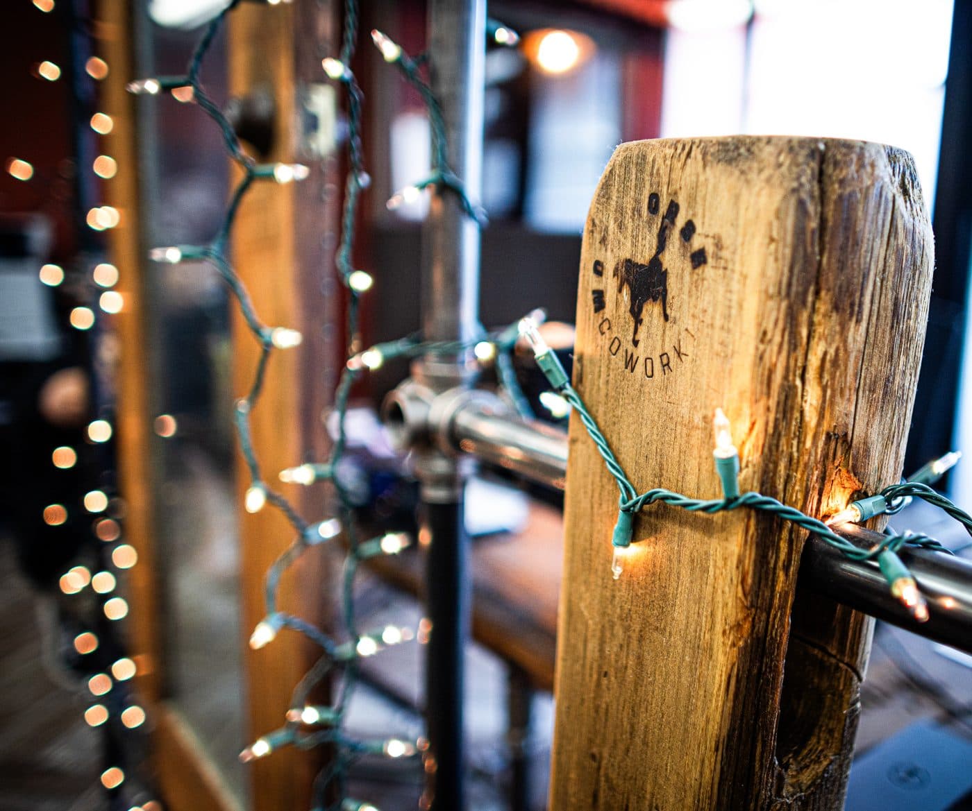 A branded timber post wrapped with string lights.