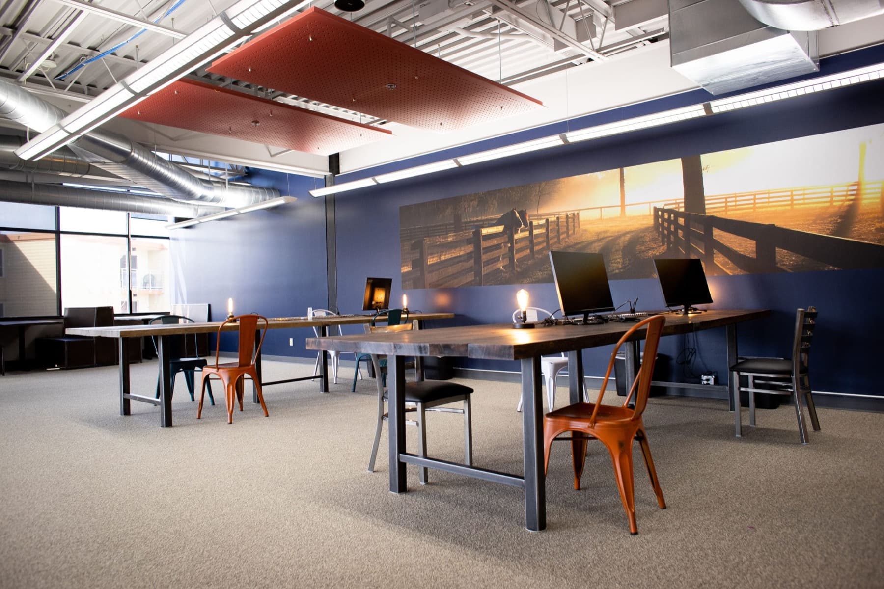 The hot-desk row along the windows, laptops open and chairs filled.