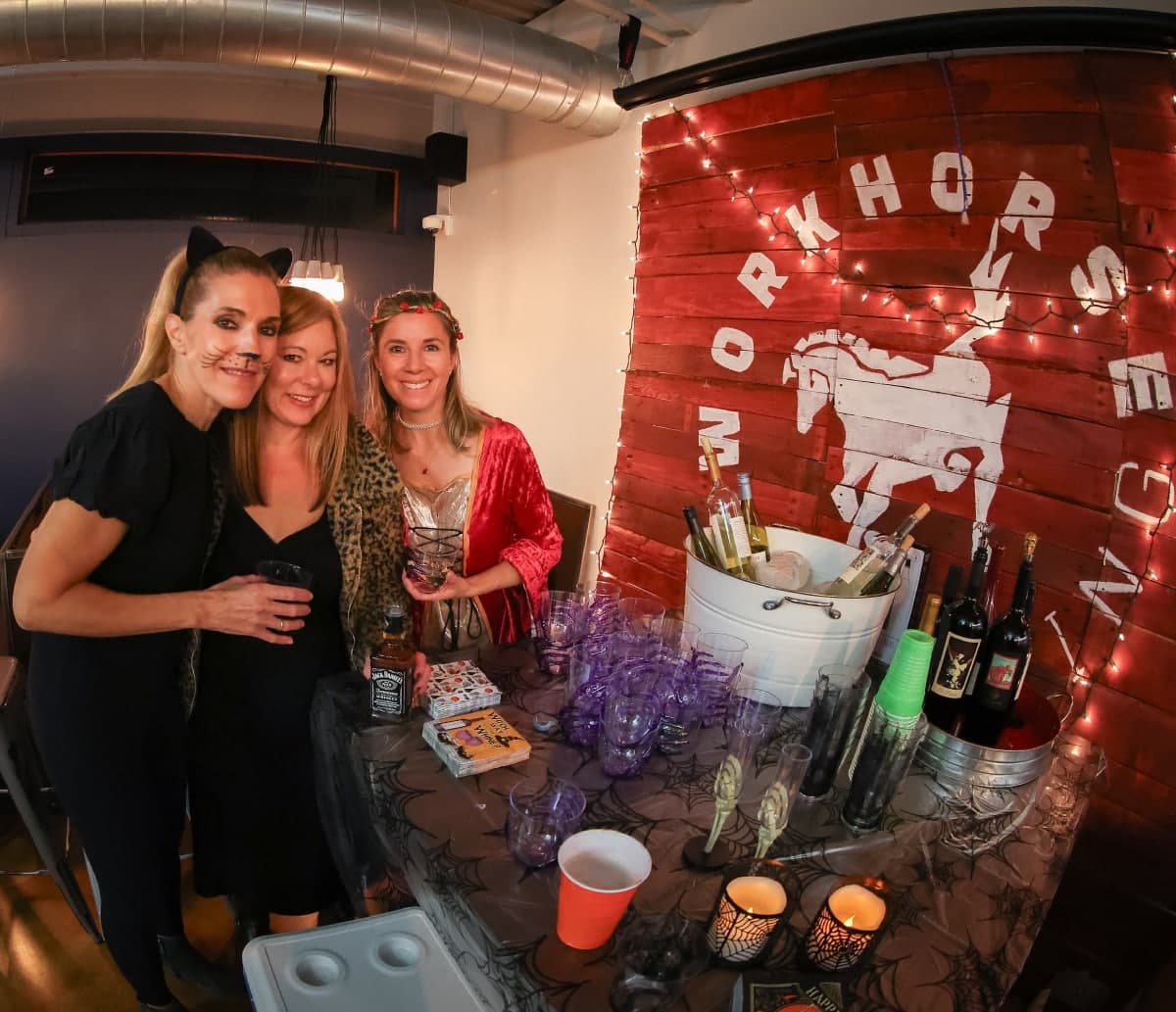 Members at a party beside the painted Workhorse sign.