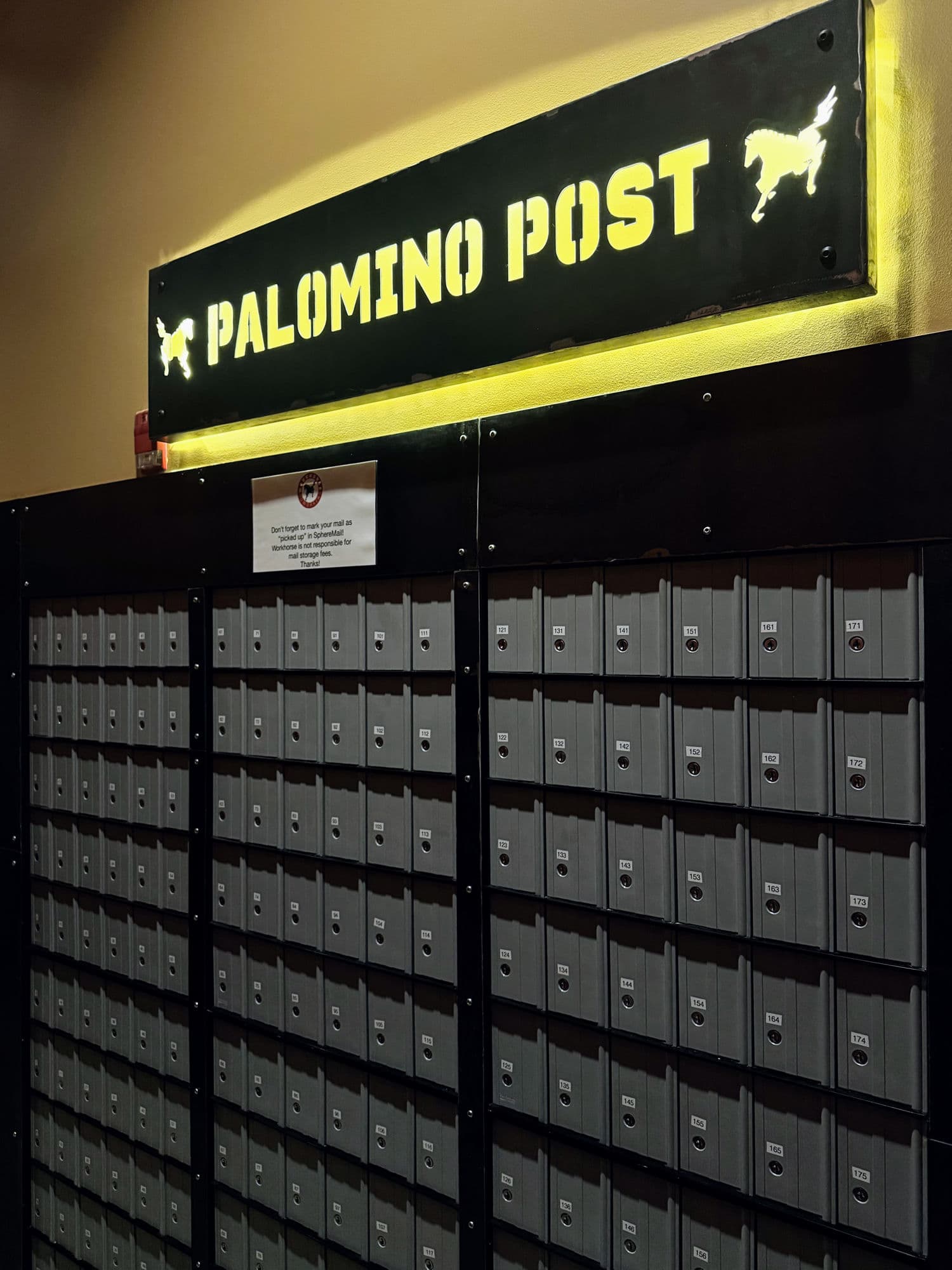 The Palomino Post mailbox wall at Workhorse — rows of numbered member mailboxes under a lit sign.