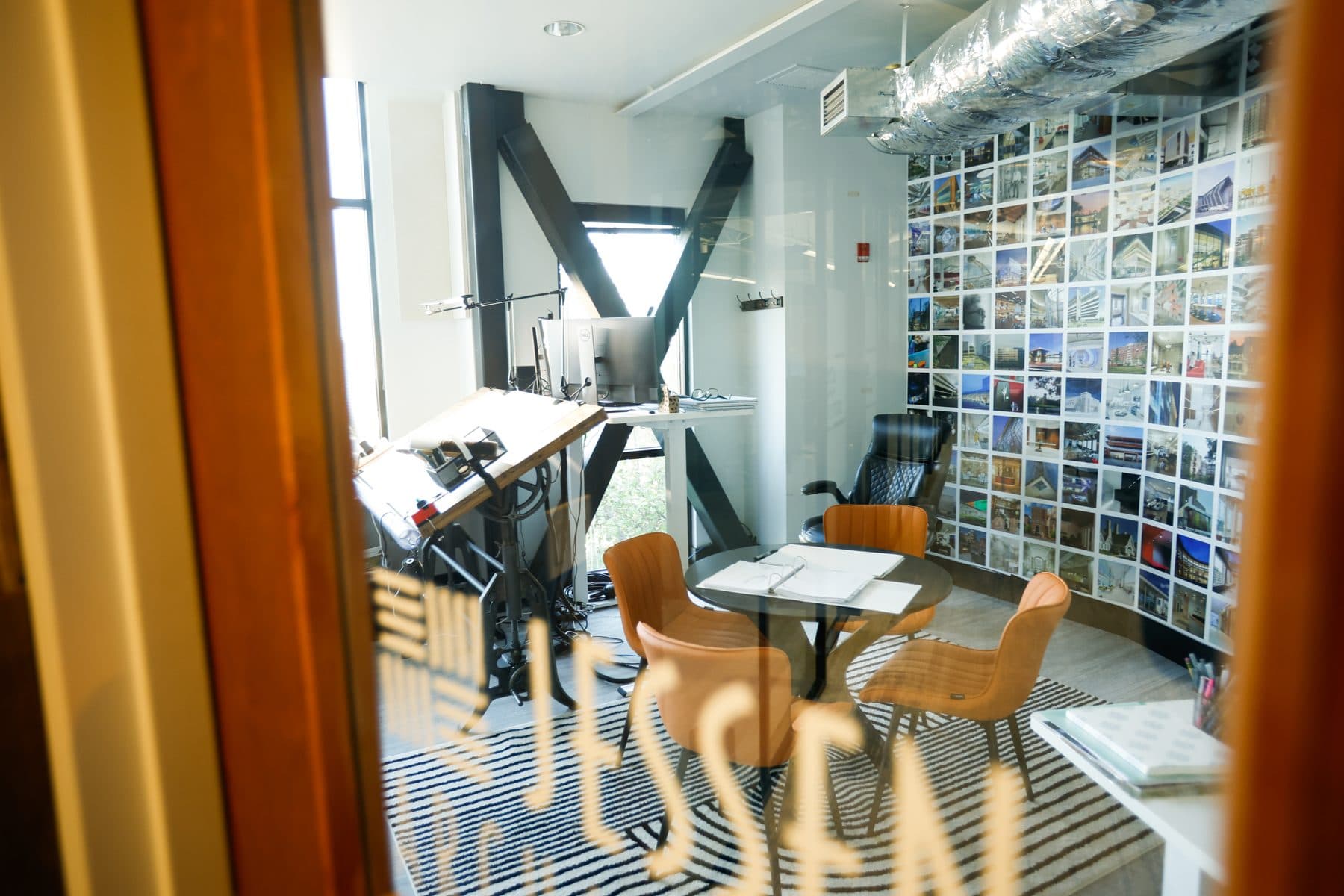 The Crescent room with its wall of photographs, a small table and two chairs.