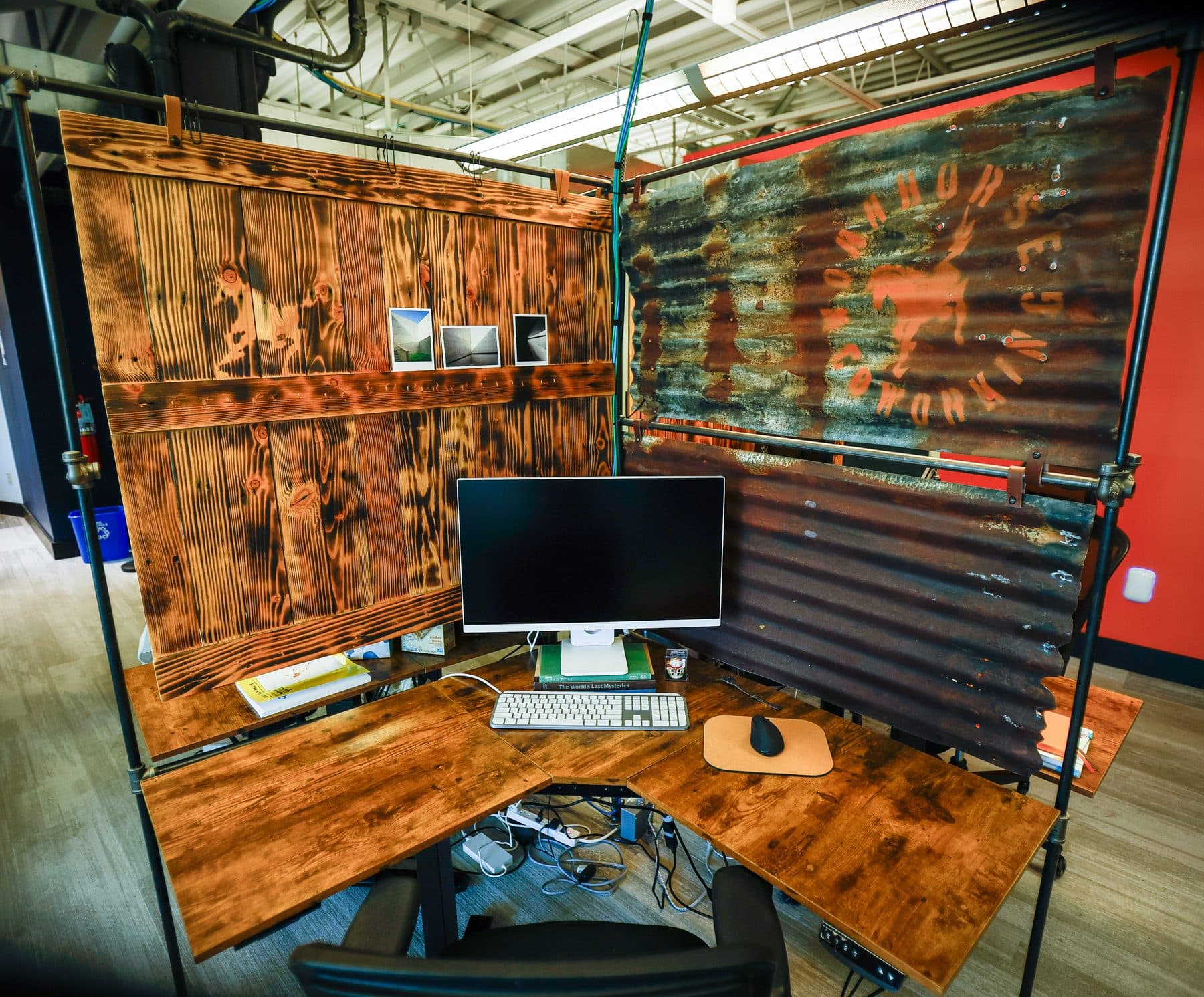 An empty dedicated desk pod with a monitor, built from reclaimed barn wood.