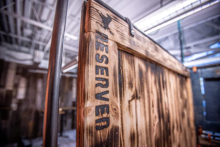 A wooden partition between desks that says "Reserved"