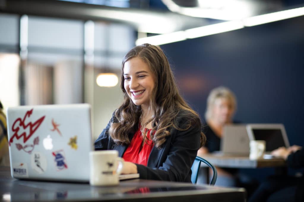 Smiling woman working at a hot desk at Workhorse Coworking