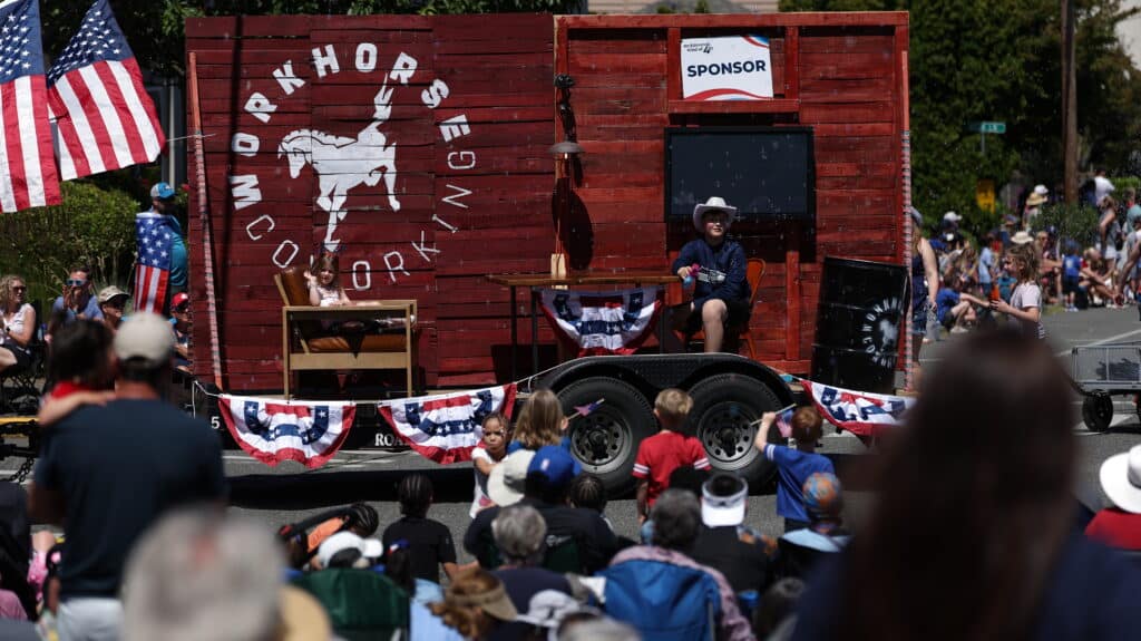 Workhorse float with a wooden wall backdrop with chairs and desks. 