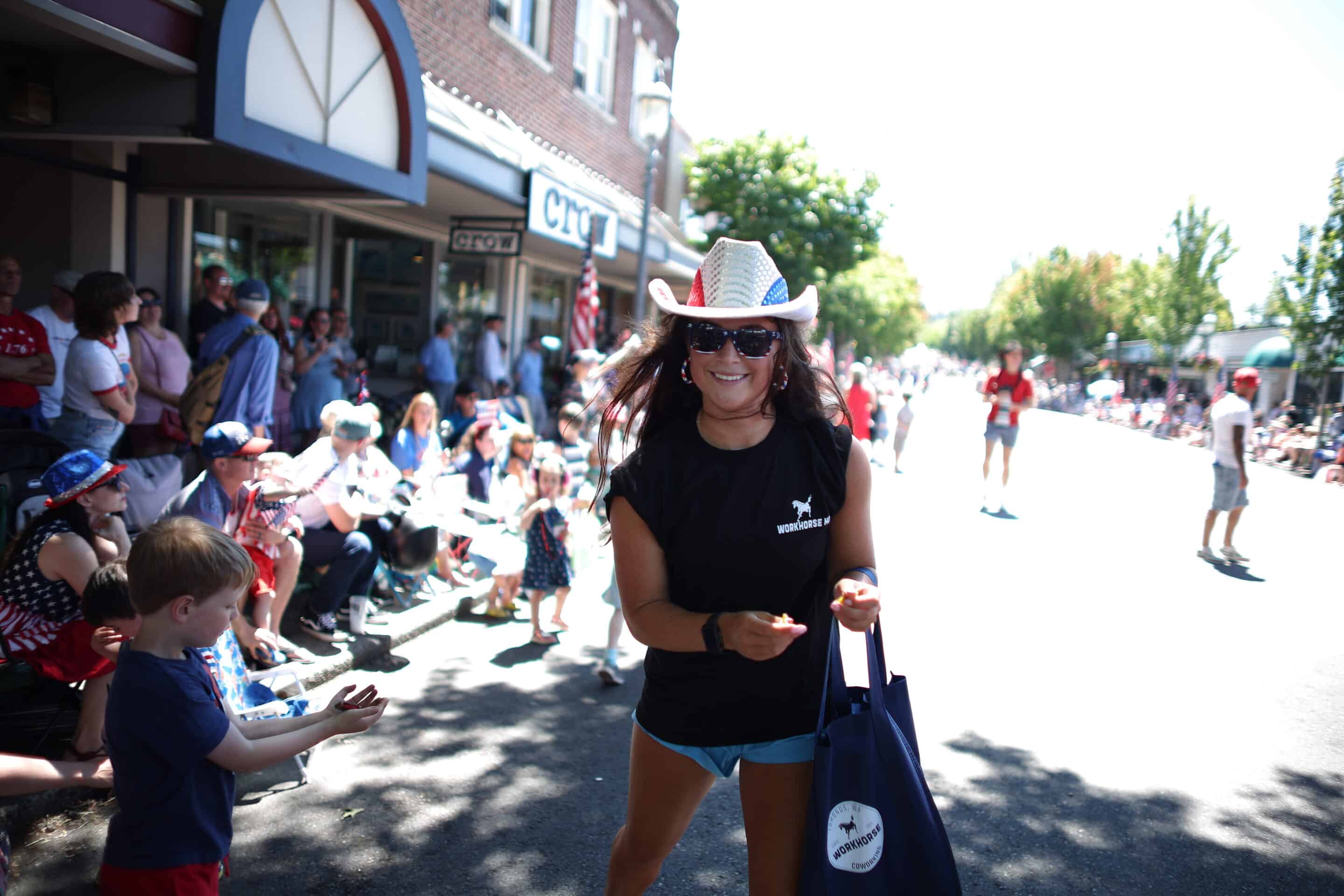 Woman in a Parade with a cowboy hat on , visiting the best shops in Edmonds.